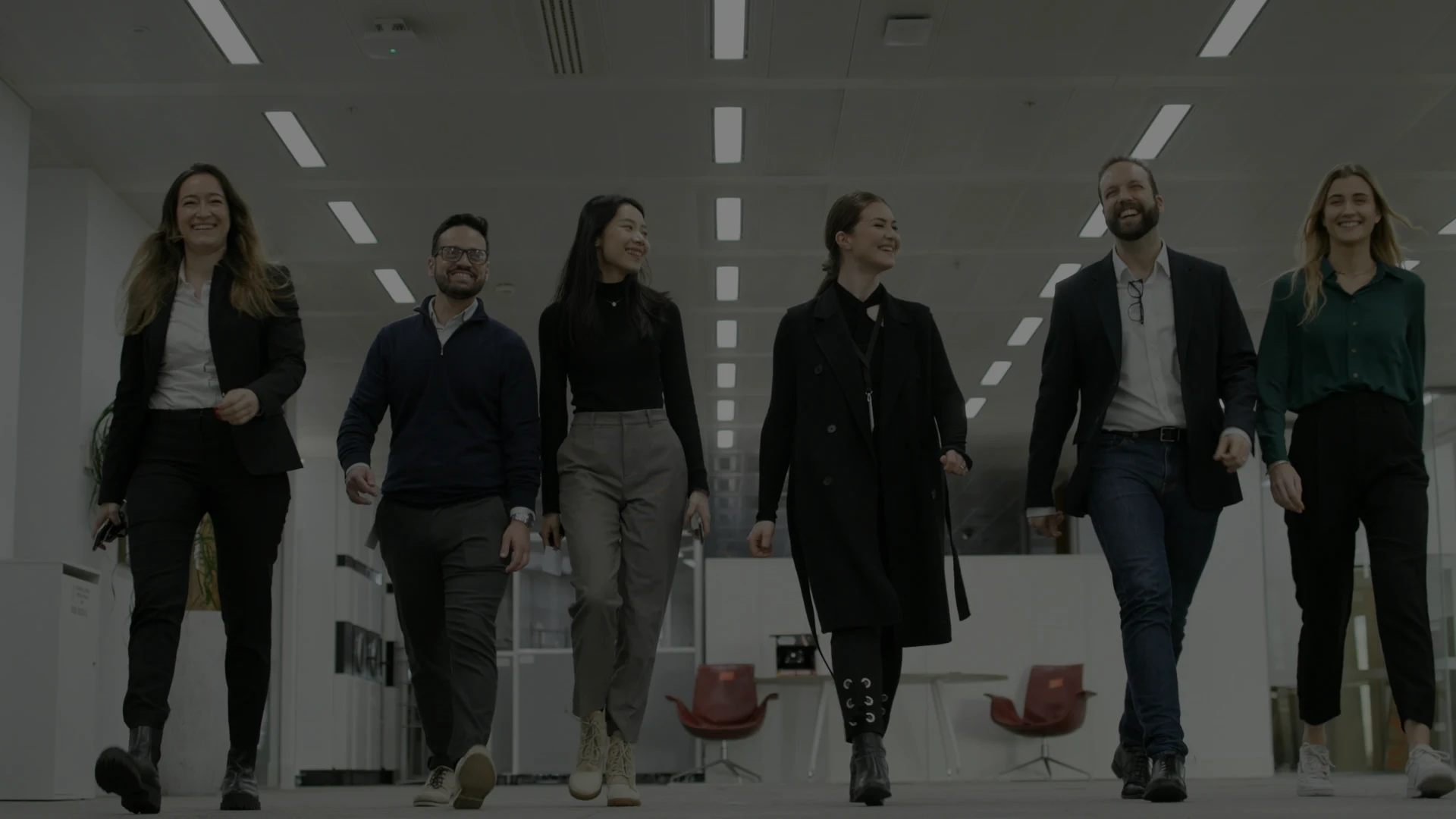 business analysts smiling and walking through office hallway